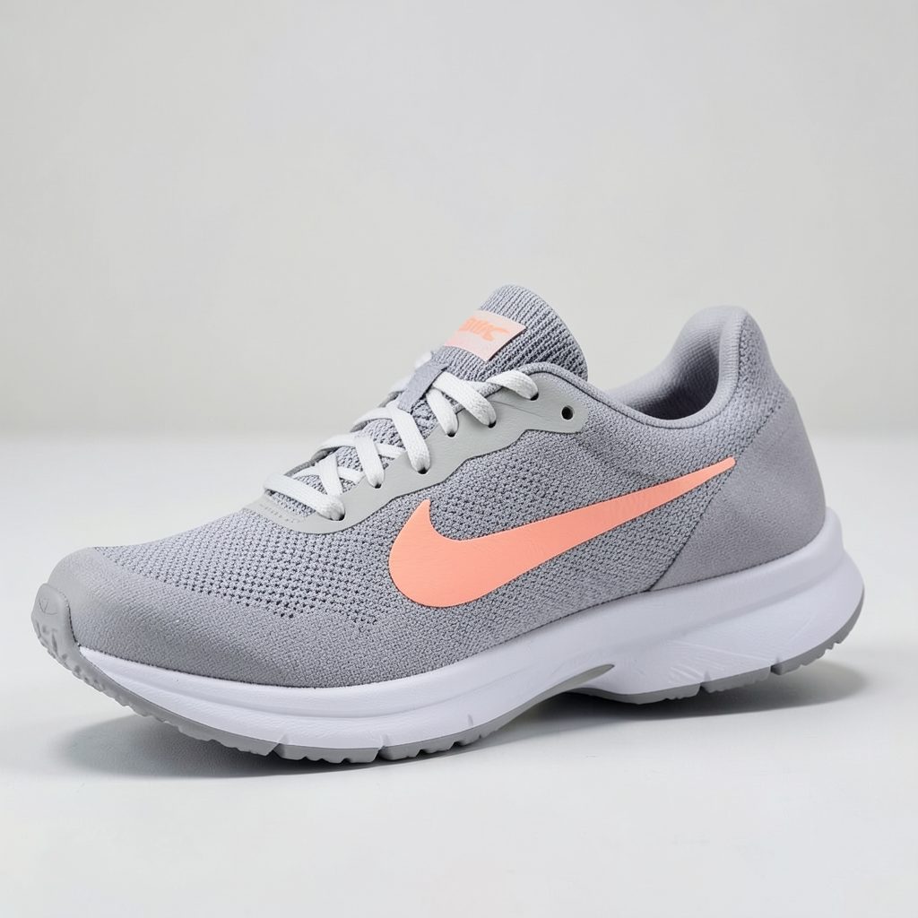 A women's running shoe in gray with a peach-red Swoosh and a soft, flexible knit upper