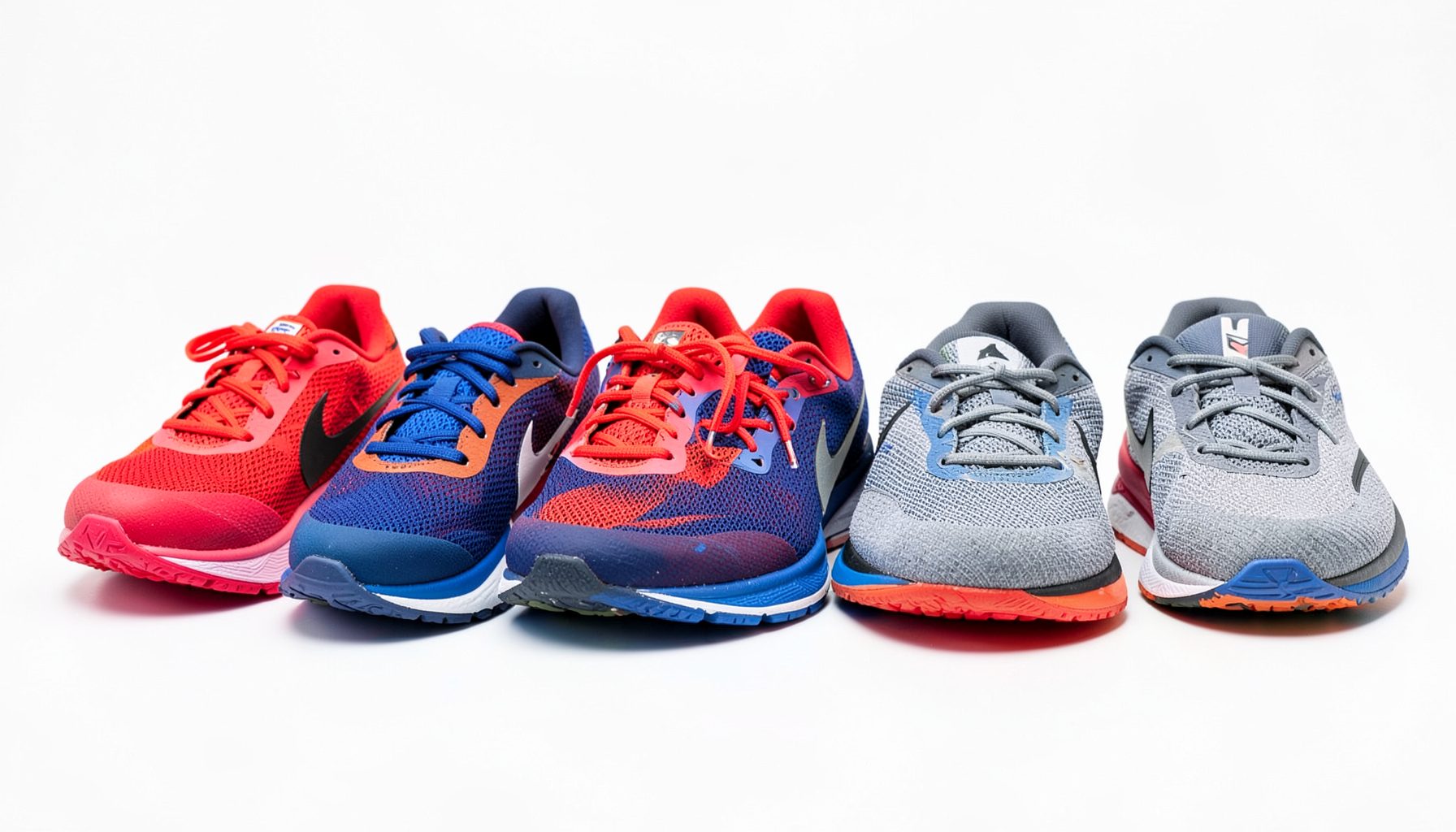 Row of colorful Nike running shoes on a clean white surface, vibrant reds, blues, and grays, athletic and energetic mood